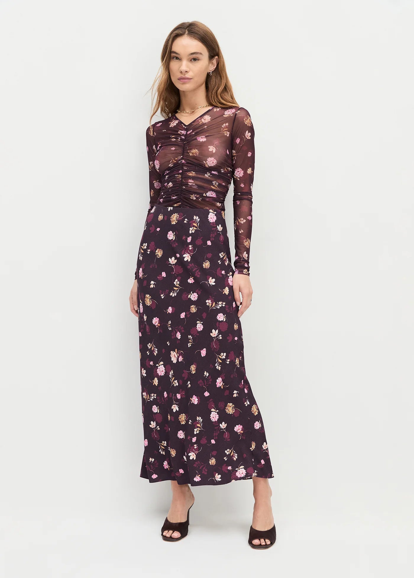 Woman wearing a dark floral dress on a white background front view 