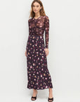 Woman wearing a dark floral dress on a white background front view 
