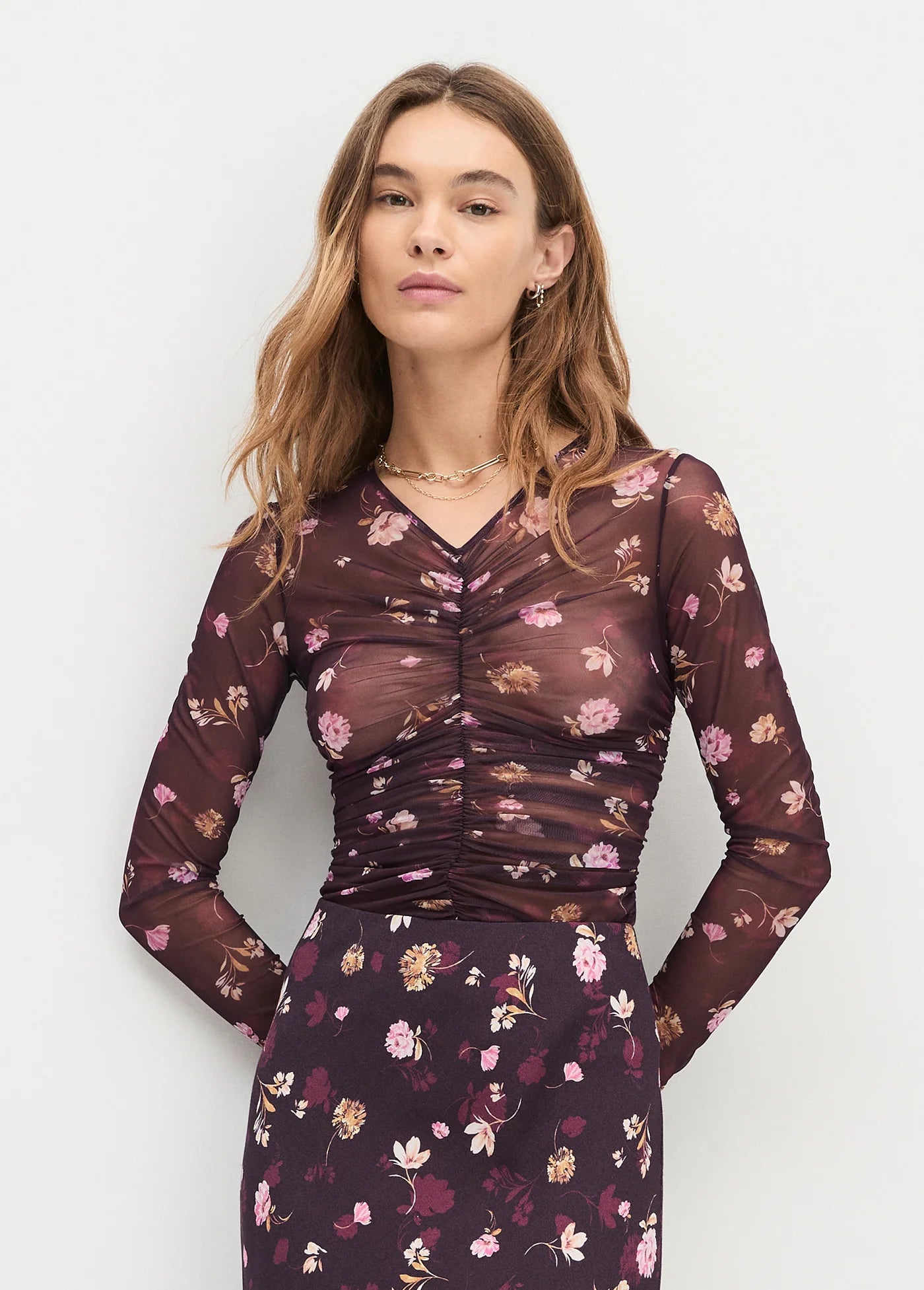 Woman wearing a floral dress with a plain background front view