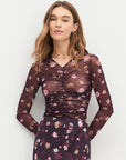 Woman wearing a floral dress with a plain background front view