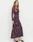 Woman wearing a floral dress on a white background side view