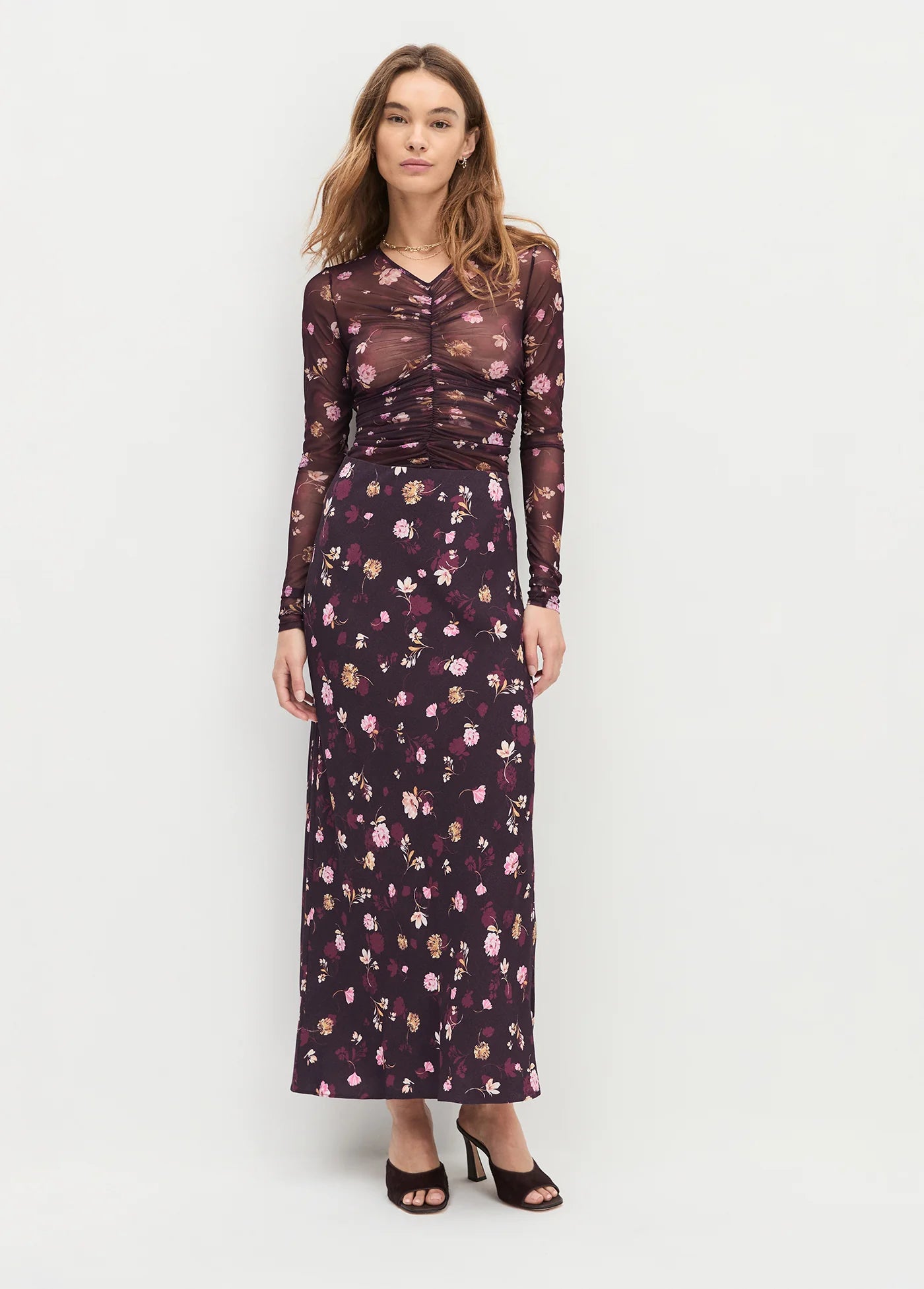 Woman wearing a floral dress with a plain background front view