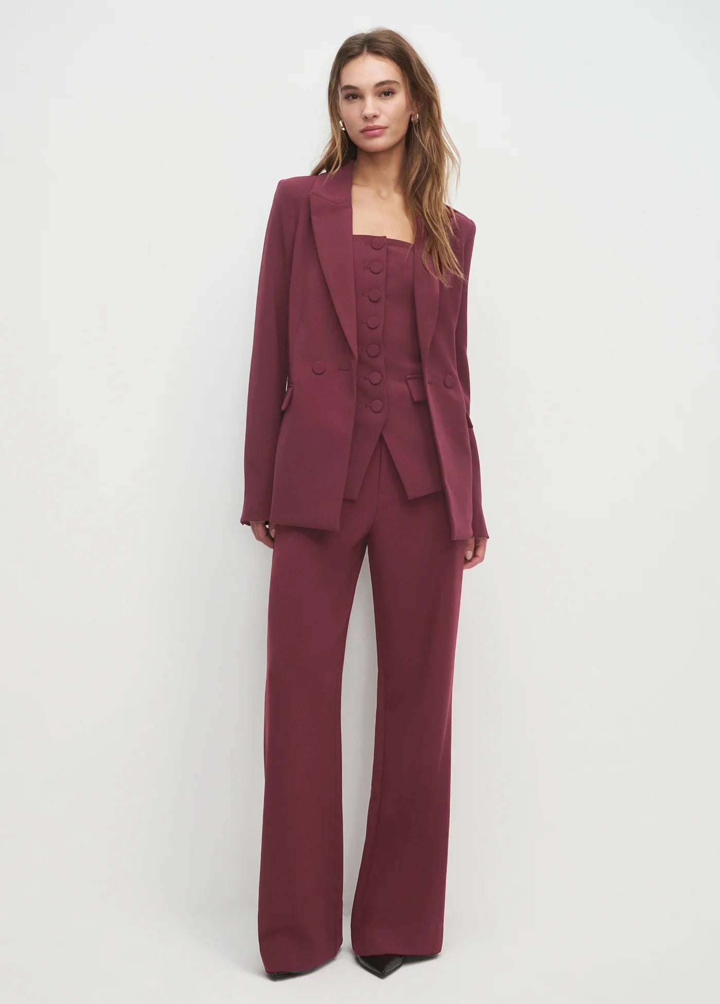 Woman wearing a burgundy suit on a white background
