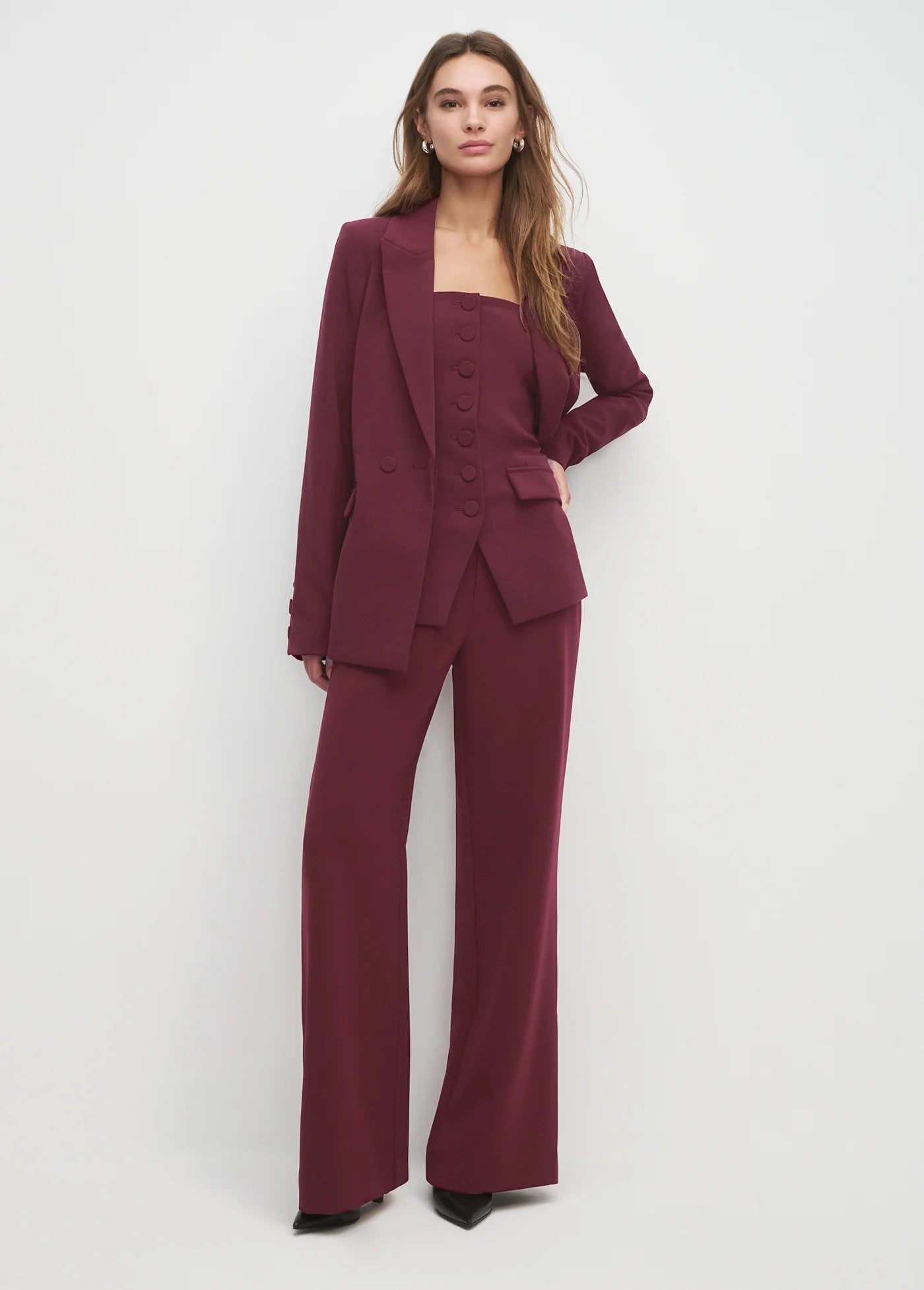 Woman wearing a burgundy suit on a white background