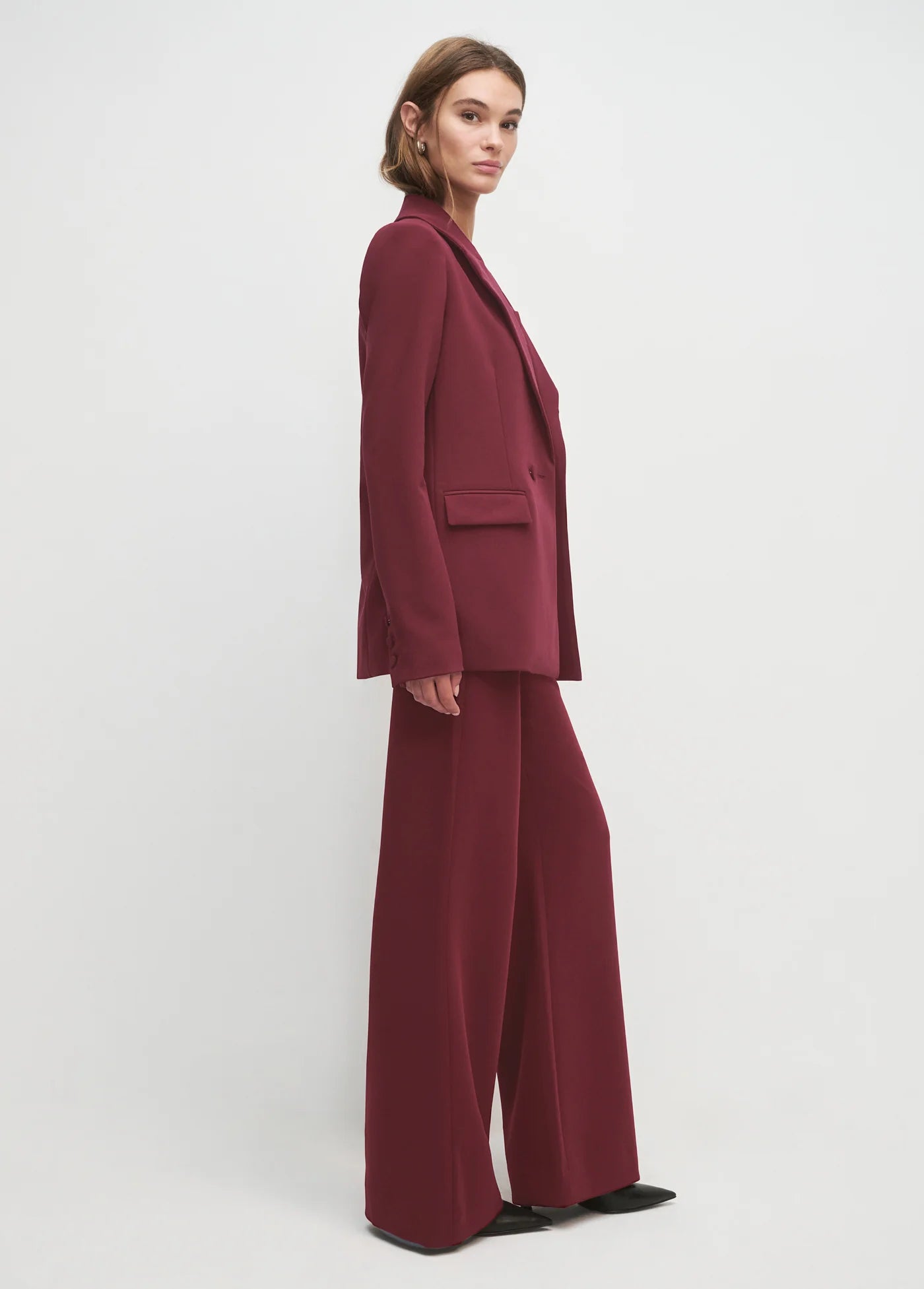 Woman wearing a burgundy suit on a white background