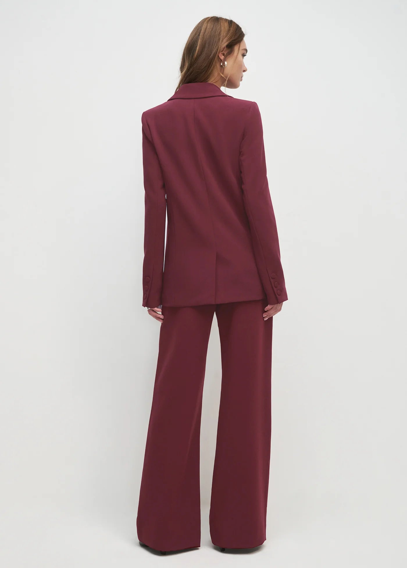 Maroon suit worn by a person on a white background