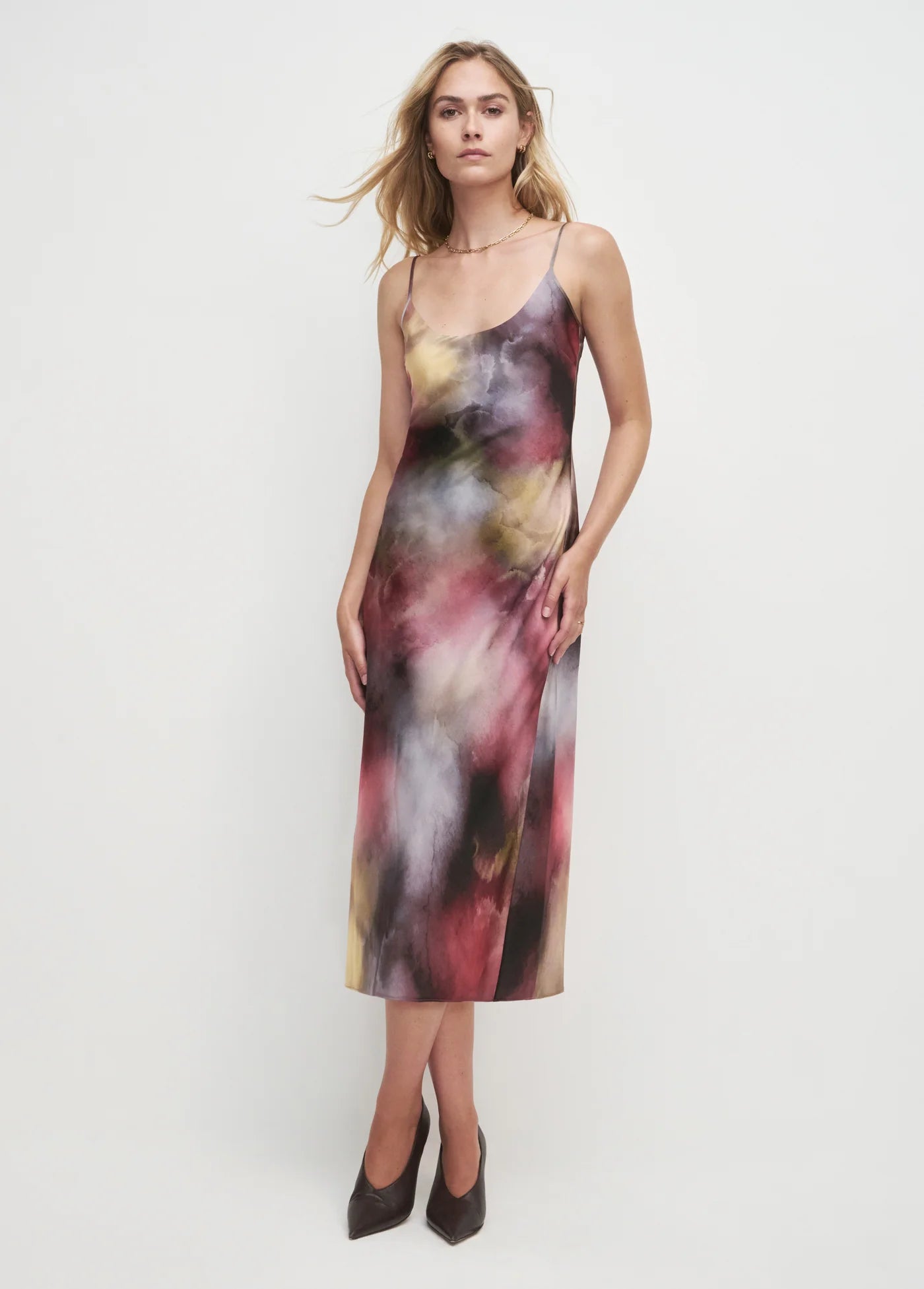 Woman wearing a colorful slip dress on a white background
