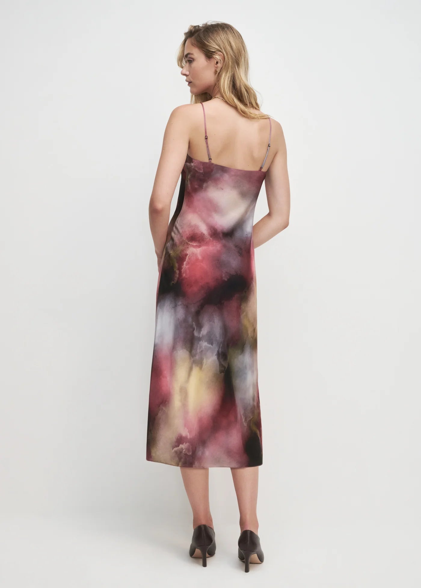 Woman wearing a colorful slip dress on a white background