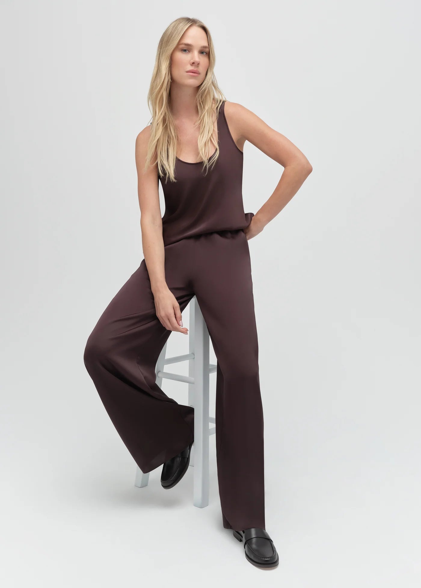 Woman wearing a brown pants and top on a white background