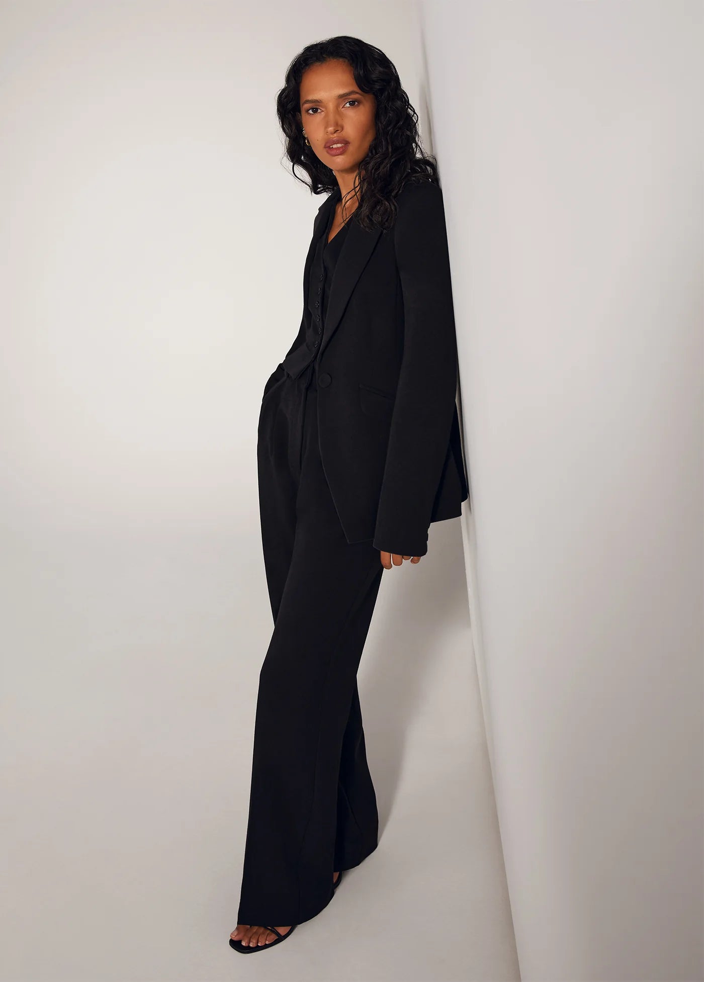The Favorite Pant in Black side view, with vest and blazer