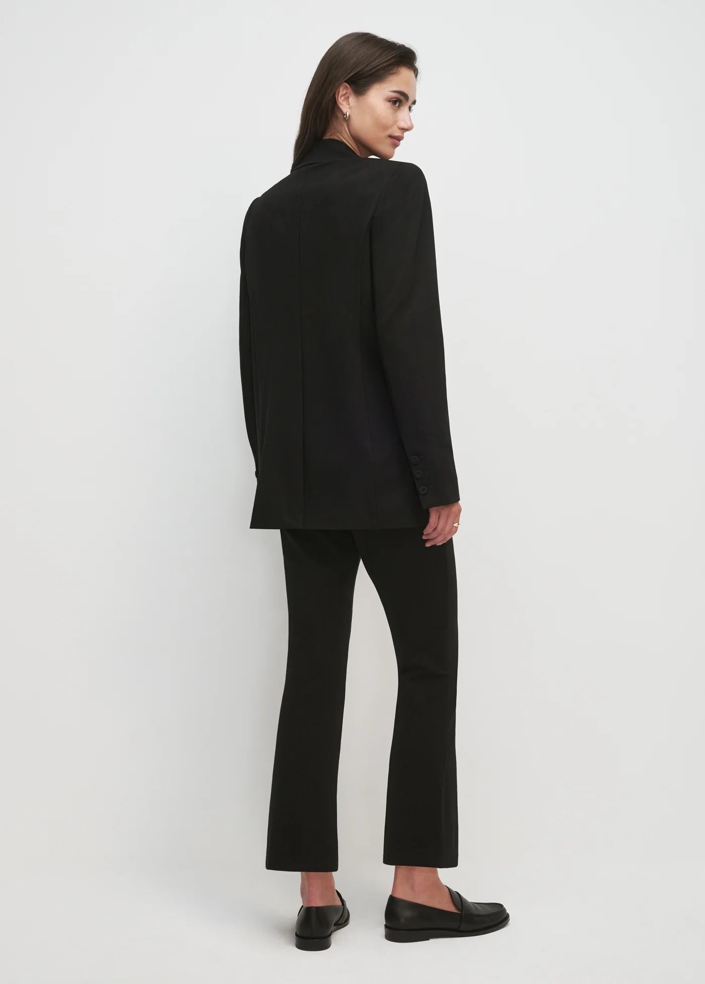 Women wearing black blazer and black pants with white background