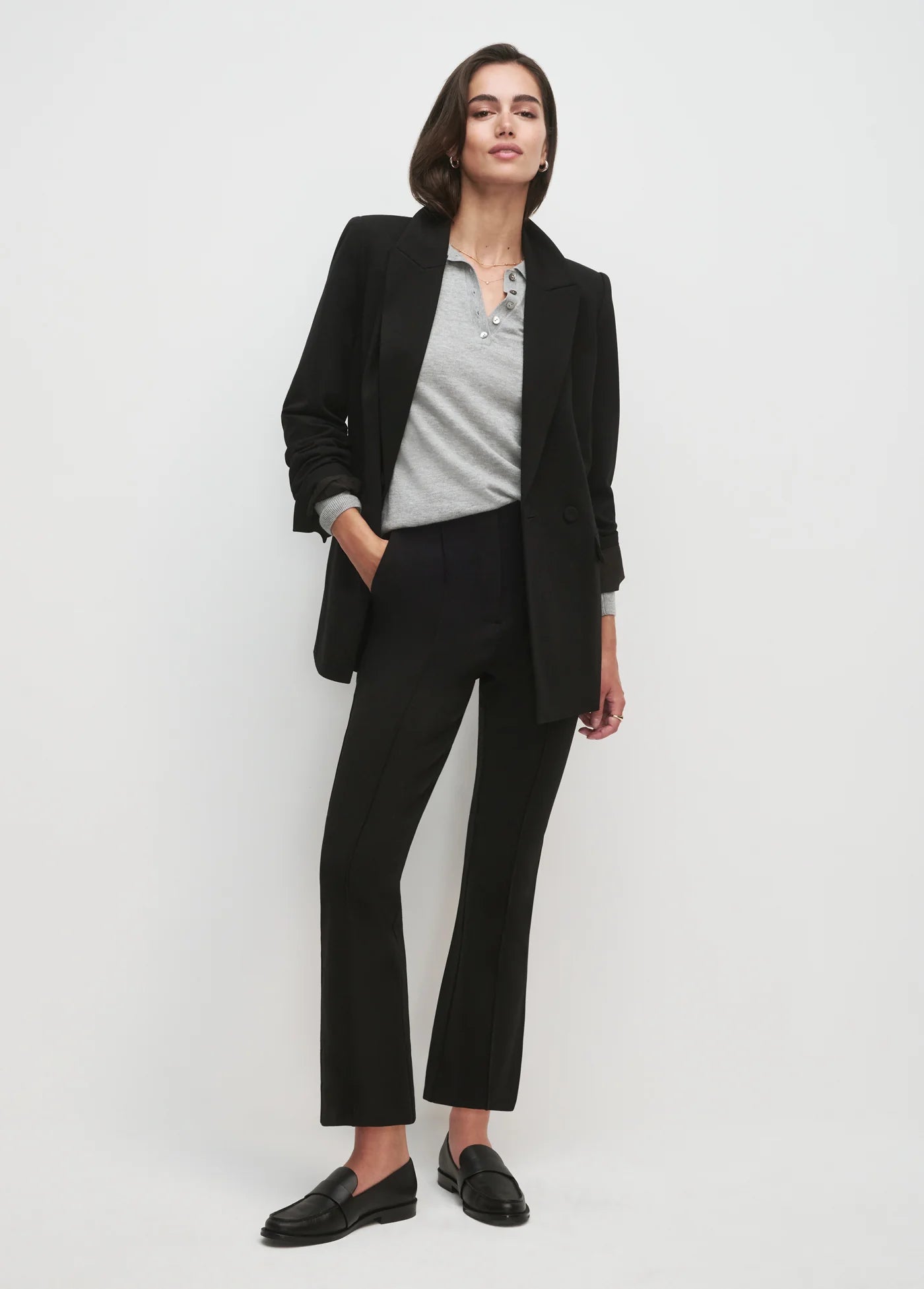 Women wearing black blazer and black pants with white background