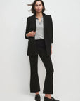 Women wearing black blazer and black pants with white background