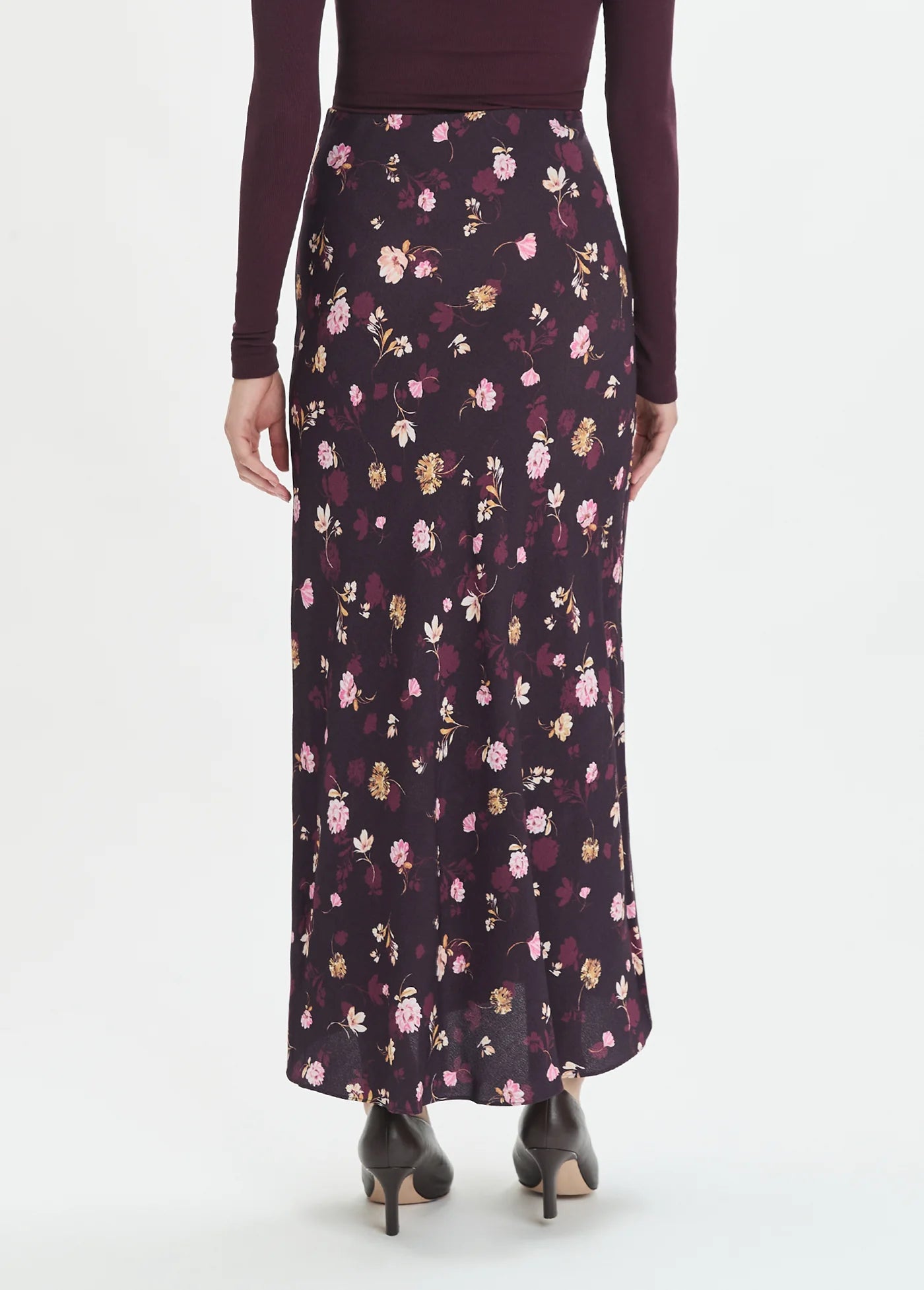 Floral patterned skirt worn by a person on a white background back view