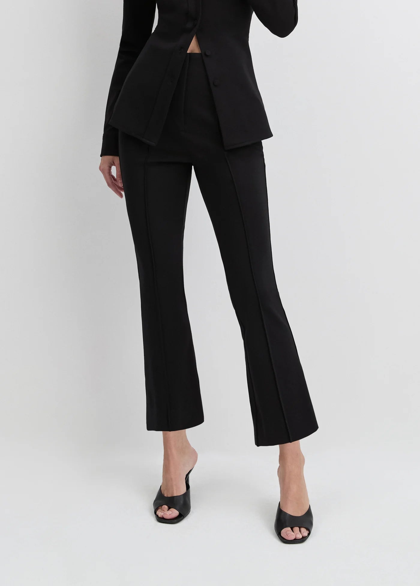 Person wearing a black suit on a white background