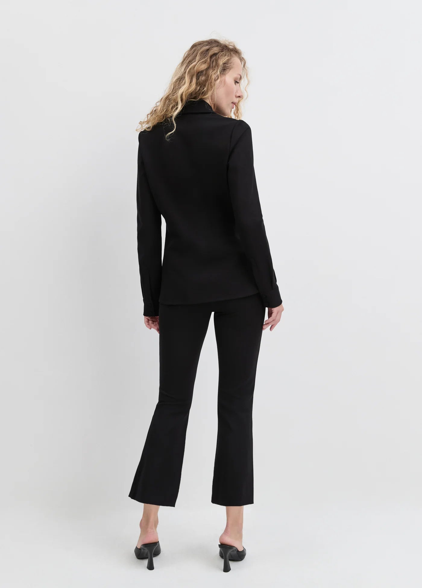 Woman wearing a black suit on a white background