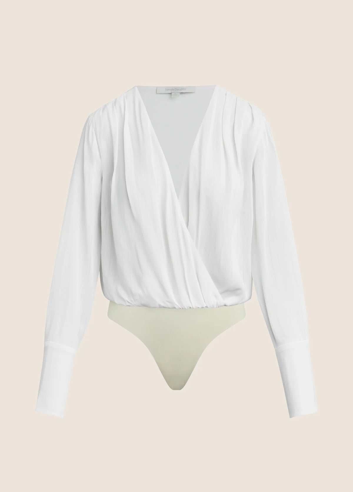 A white long-sleeve draped wrap top with a deep V-neckline, styled over a light beige thong, shown against a solid pale beige background.