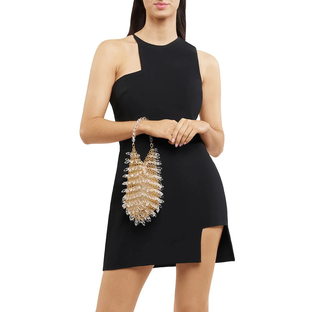 Woman wearing a black dress holding a decorative handbag on a white background