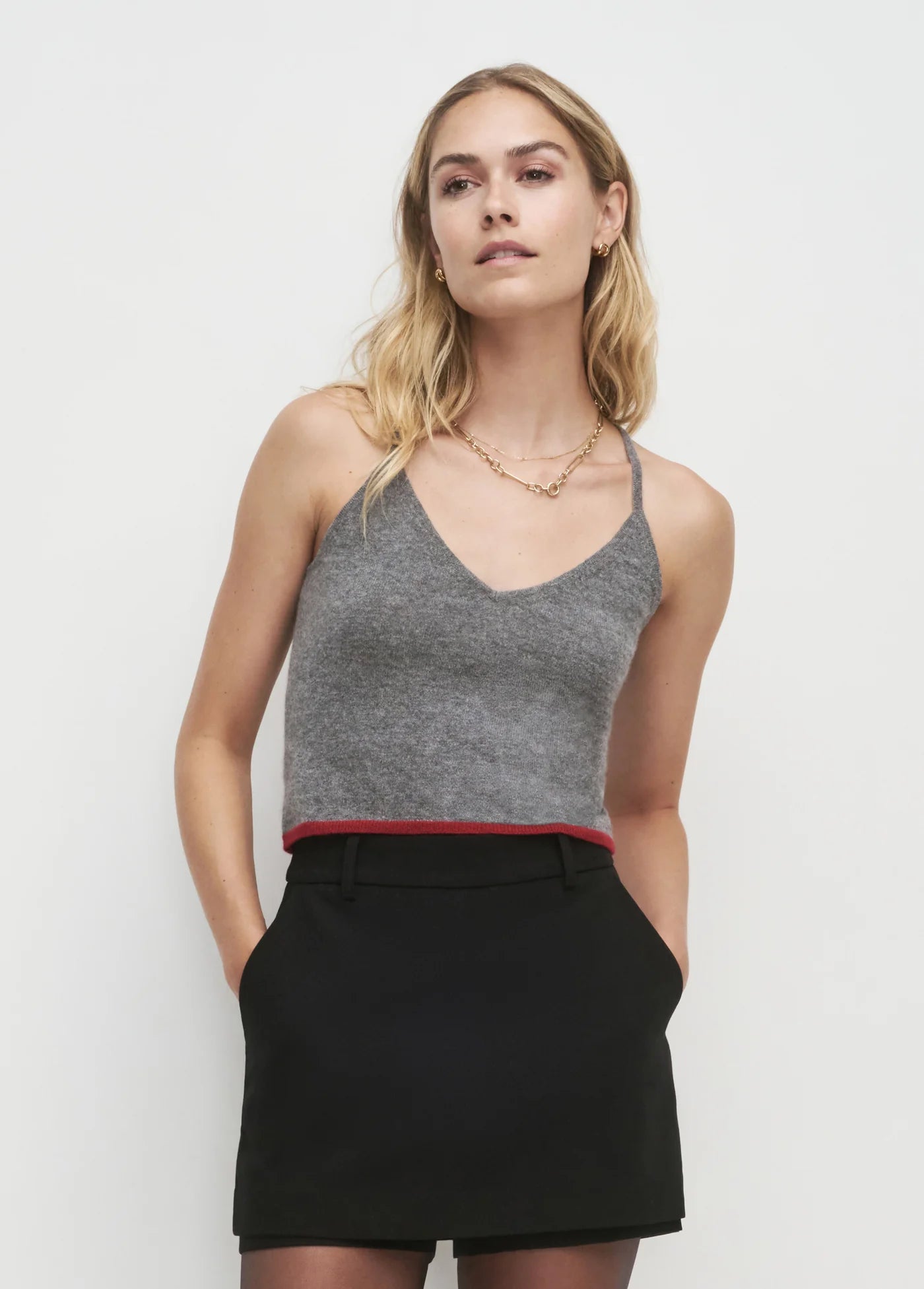 Woman wearing a gray tank top and black skirt on a white background