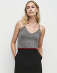 Woman wearing a gray tank top and black skirt on a white background