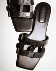 Black flat sandals on a white background