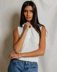 model wearing a white collared shirt with jeans on a white background