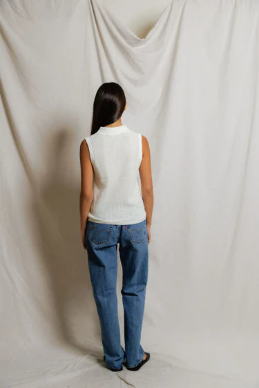 model wearing a white collared shirt with jeans on a white background, back view
