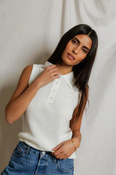 model wearing a white collared shirt with jeans on a white background