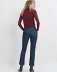Woman wearing a burgundy sweater and blue jeans on a white background