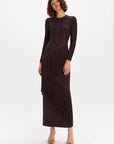 A woman modeling a long-sleeve, dark brown fringe maxi dress against a plain white studio background.
