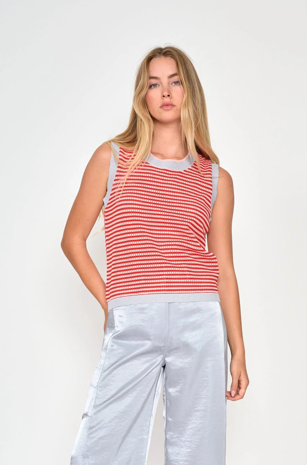 model wearing stripe top with shiny pants on white background