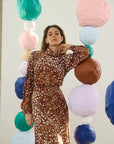 model wearing dapple doe printed top and skirt with art paper mache balls in the background