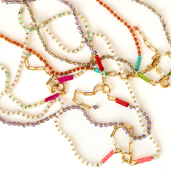Colorful beaded necklaces and bracelets on a white background