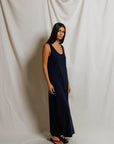 Woman wearing a long navy dress against a plain white background