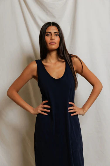 Woman wearing a navy blue dress against a plain background