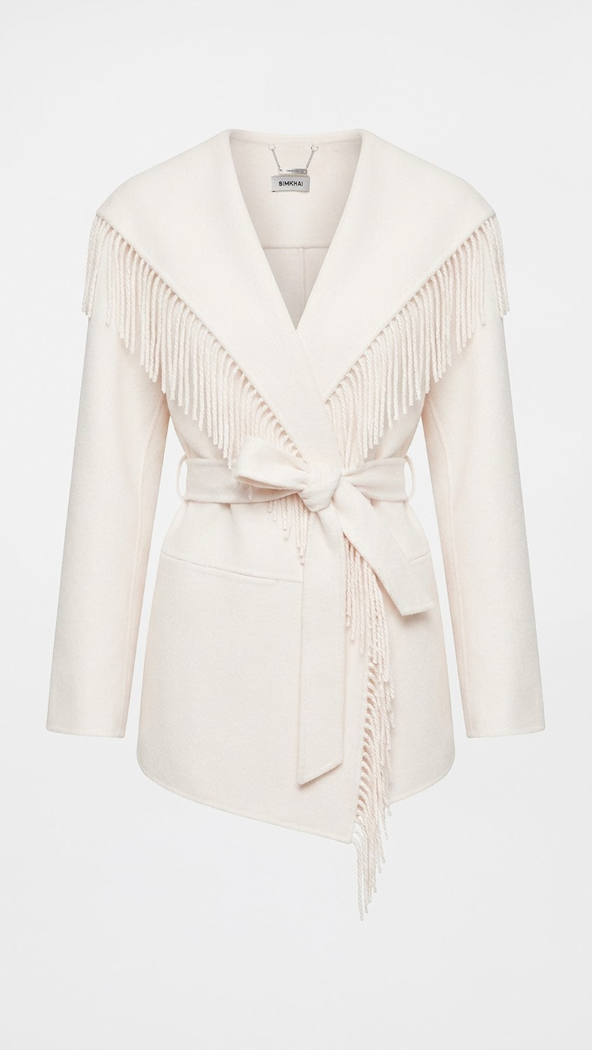 An off-white wrap coat with long fringe detailing across the shoulders and a matching waist tie, shown on a plain white background.