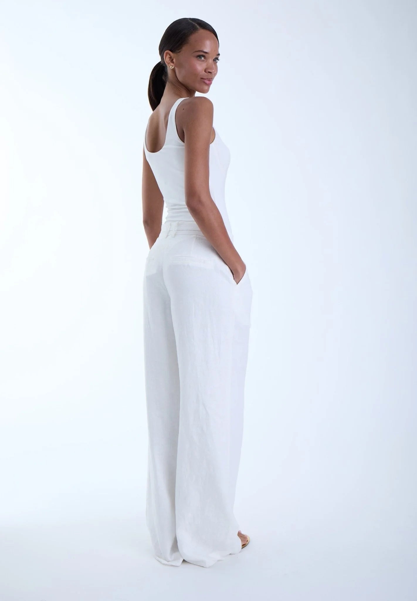 Woman wearing a white outfit on a light gray background
