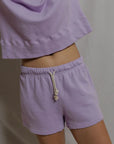 model wearing a purple lounge set on a white background