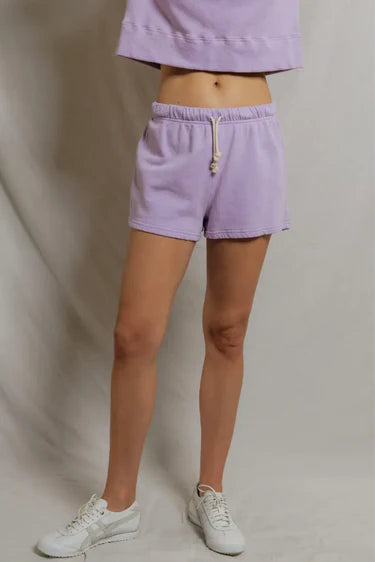 model wearing a purple lounge set on a white background