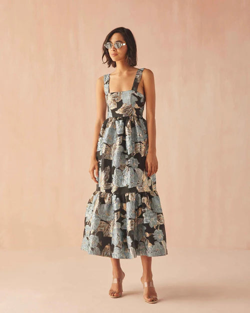 Woman wearing a floral dress against a pink background