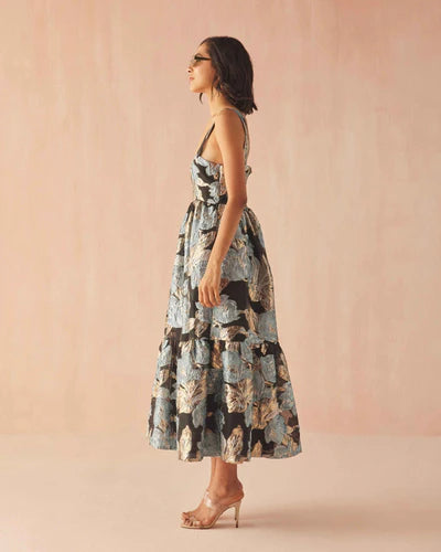 Woman wearing a floral dress against a pink background