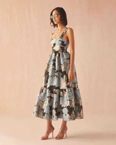 Woman wearing a patterned dress against a pink background