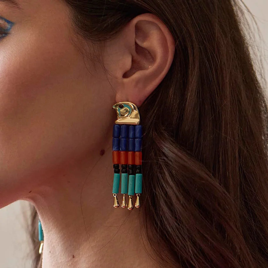 model wearing colorful earrings on a beige background