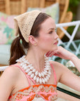 woman wearing a crochet headband with a colorful background