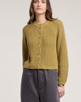 model wearing a khaki chunky cardigan on a cream background