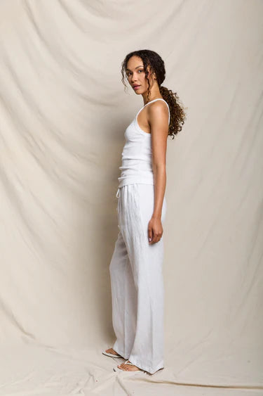 Woman wearing a white outfit against a plain background
