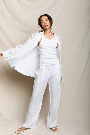 Woman wearing a white outfit against a plain background