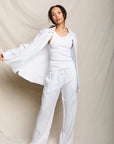 Woman wearing a white outfit against a plain background