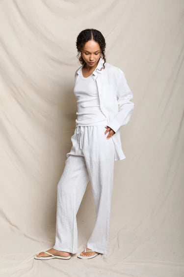 Woman wearing a white outfit against a plain background