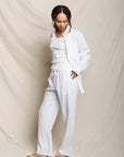 Woman wearing a white outfit against a plain background